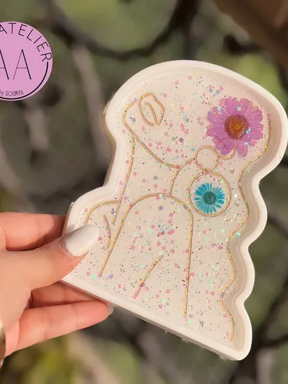This white glitter lady trinket tray adds a touch of sparkle to any space. It's perfect for holding jewelry, keys, or other small essentials.