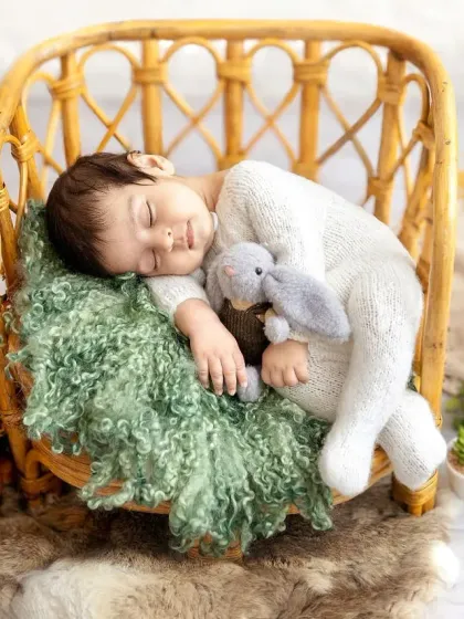 Curled up and dreaming in a lovely rattan chair. The combination of natural textures and a soft, knitted outfit creates such a cozy and organic feel for this newborn photo.