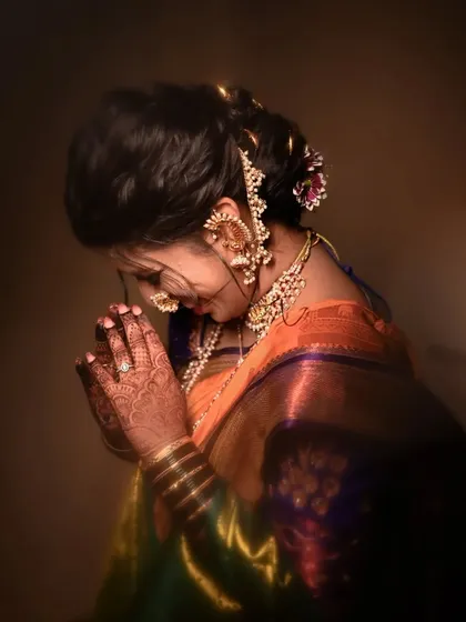 A traditional pose of the bride in a moment of prayer or reflection, highlighting the intricate jewelry and hairstyle from the side.