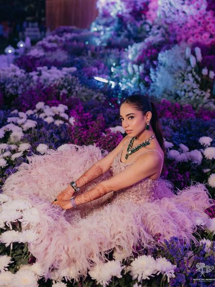 The bride sitting in a field of flowers, looking like a princess from a fairytale.