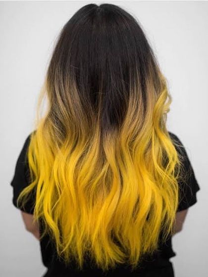 Another view of the striking yellow ombre, showcasing the seamless blend from dark roots to electric yellow ends, styled with soft waves.
