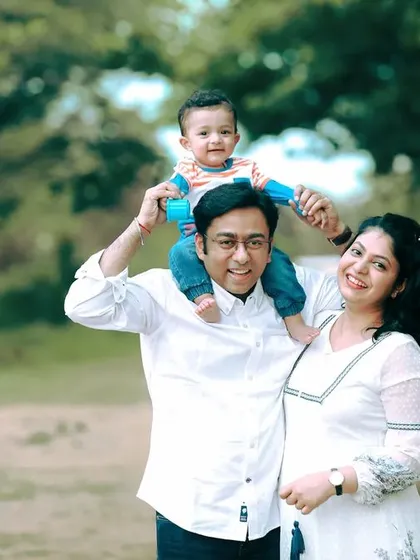 A happy family portrait taken outdoors in Bangalore, with everyone relaxed and smiling. I love capturing these natural moments of connection.