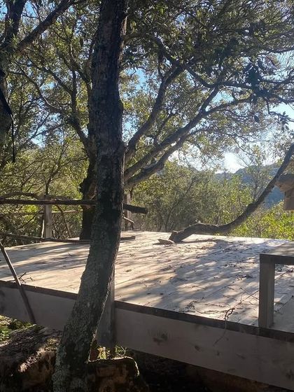 Another view of the yoga deck built amongst the trees in Sardinia. Practicing here allows for a deep connection with the surrounding forest and fresh air.