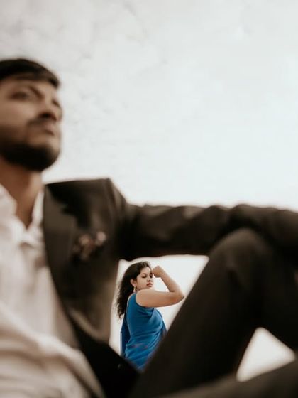 A low-angle, artistic shot focusing on the groom in the desert, creating a dramatic and thoughtful mood.