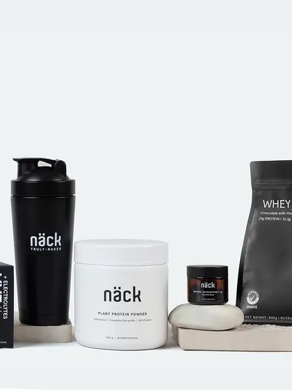 A clean and minimalist product shot for a line of fitness supplements. The monochrome color scheme and geometric arrangement on concrete blocks create a strong, modern, and powerful brand image.