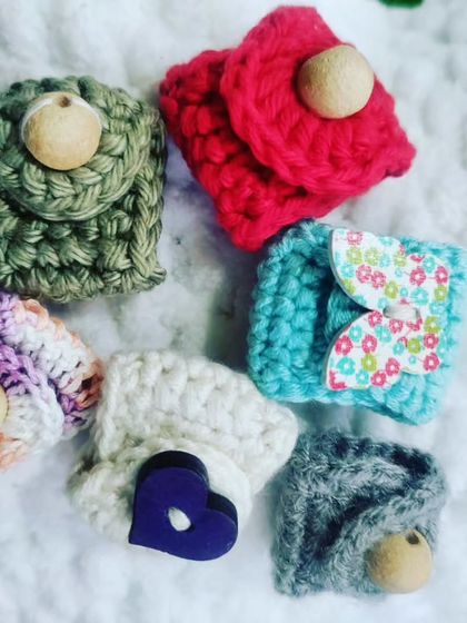 A variety of my handmade cable and wire organizers. They come in different colors and styles, using buttons or fabric to add a unique touch.