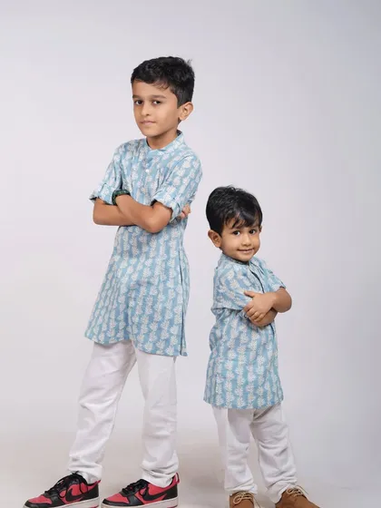 Brothers striking a cool pose in matching kurtas. This studio shot captures their fun personalities and the special bond between siblings.