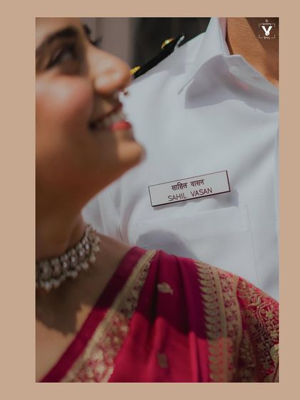 A close-up shot focusing on the groom's name tag on his Navy uniform, with the bride looking up at him lovingly. A unique and personal detail from their Mumbai court wedding.