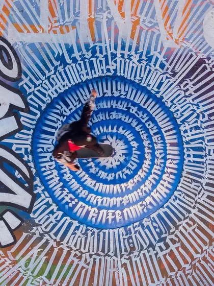 An overhead shot of a skater mid-air, perfectly centered in the calligraffiti vortex I designed for the Carter Road Skatepark project. This piece was the heart of a massive collaboration, blending street art with skate culture.