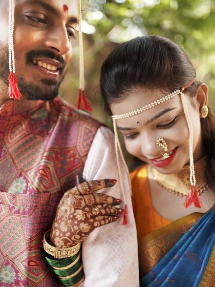 A close-up shot capturing the bride's mehendi-adorned hand on the groom's arm, a detail full of love.