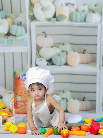 A baby chef crawling amidst a colorful array of toy foods and props. This theme is great for capturing your little one's curiosity.