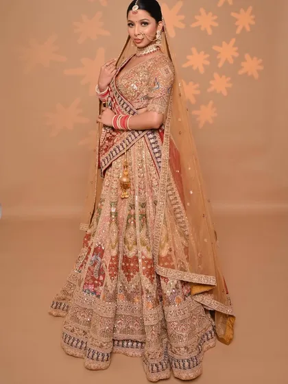 Embrace the golden era with this heavily embroidered multi-color lehenga. The rich gold base is complemented by panels of traditional colors, creating a regal and unforgettable bridal outfit.