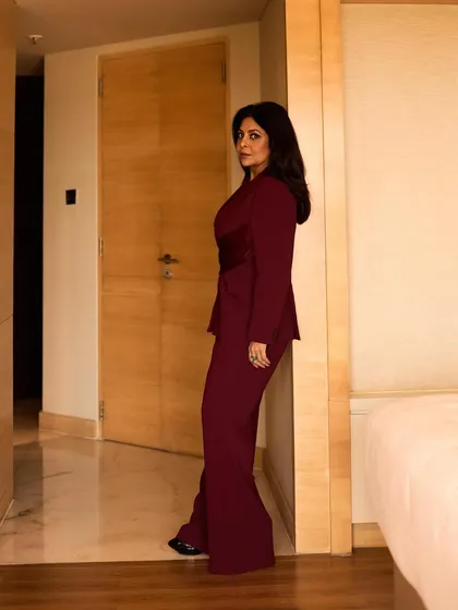A full-length view showing the flared trousers and strong silhouette of this custom-designed power suit.