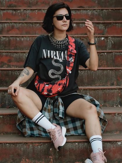 A closer look at the custom Selena Artichoke Red, worn as a crossbody bag. The tie-dye pattern and wide strap make it a unique piece for a casual, grunge-inspired look.