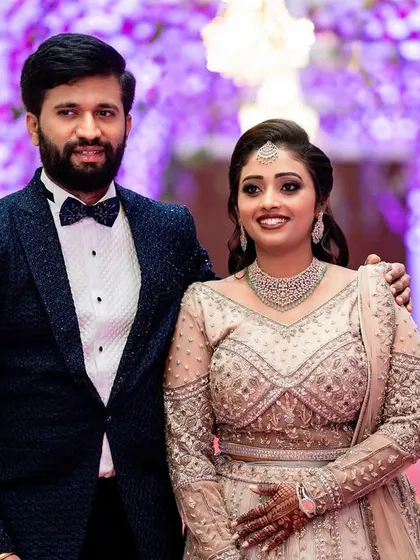 An elegant couple making their grand entrance at their wedding reception. This photo captures the glamour and celebratory atmosphere of the evening, framed by beautiful floral decor.