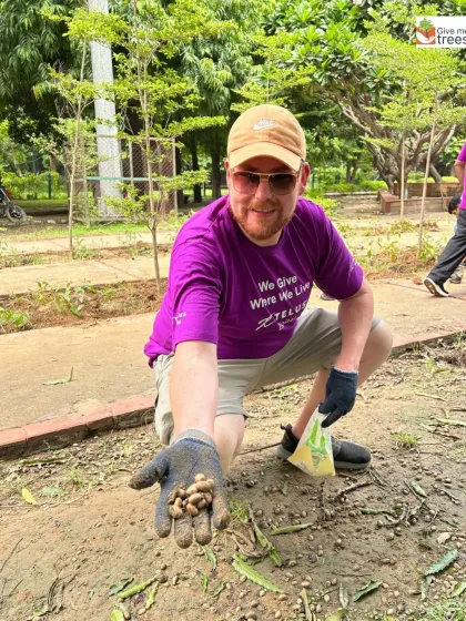 A Telus volunteer shows a handful of collected seeds. This simple activity connects our partners directly to the cycle of forest regeneration.