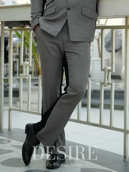 A detail shot of the grey and black trousers, highlighting the contrasting side panel and the quality of the fabric.