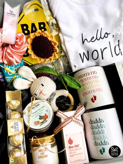 This 'Baby Coming Soon' hamper is bursting with goodies for the parents-to-be, including custom mugs, a 'Hello, World' onesie, Bio-Oil, a crochet rattle, and a scented candle.