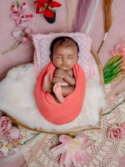 A little blossom in a field of pink. This beautiful flat-lay composition uses flowers and fabrics to create a soft, textured bed for the baby.