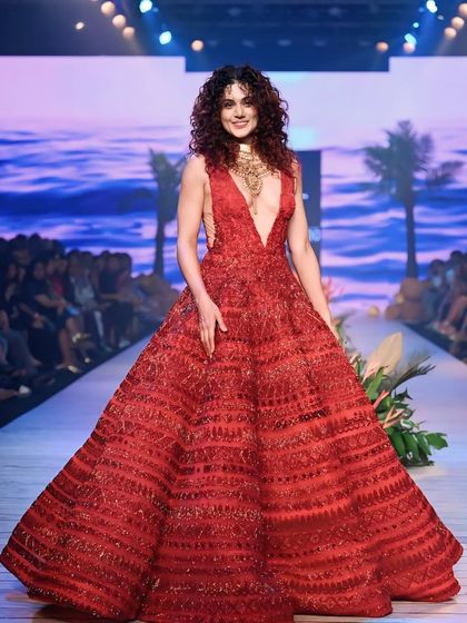 A full view of Taapsee Pannu on the runway, set against a tropical-themed backdrop. This image shows how the set design complements the fashion.