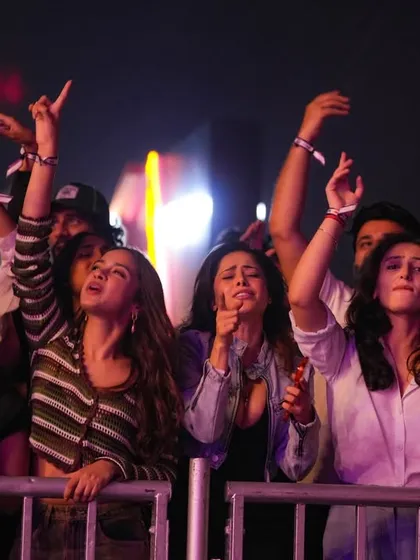 The front-row fans in Mumbai, reaching for the sky. Their energy fuels the entire arena.