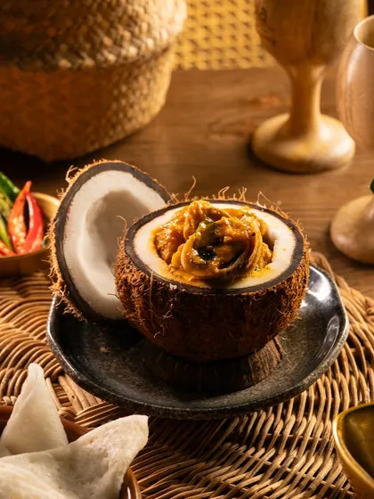 A coastal specialty, Marvai Pundi, served in a coconut shell. The unique presentation immediately tells a story about the dish's origins.