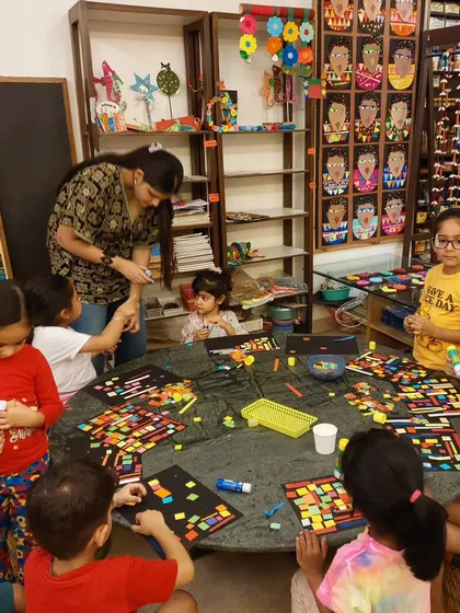 My toddlers are creating their own versions of African Kente cloth patterns using colorful paper collage. It's a great introduction to geometric art.