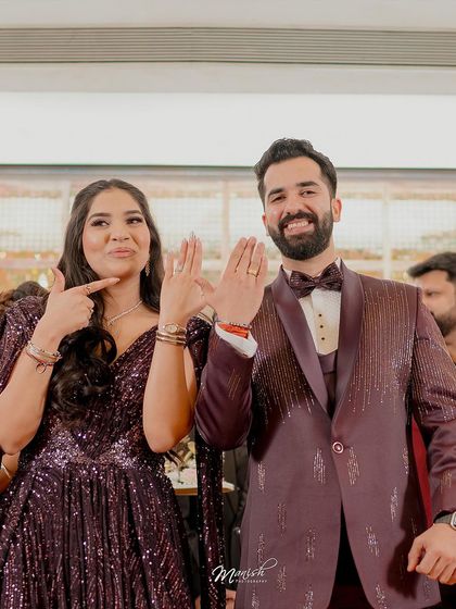 The happy couple showing off their engagement rings, a fun and proud moment captured perfectly.
