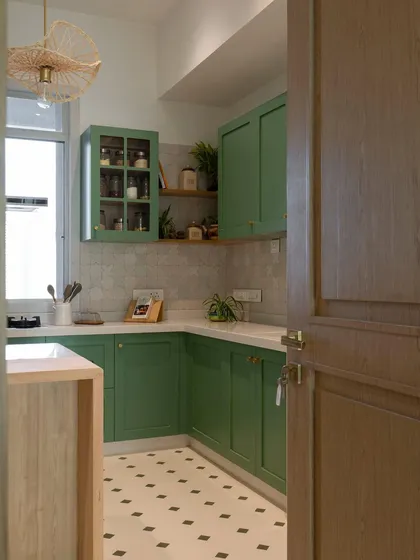 A view into this inviting green kitchen, where patterned floor tiles lead the eye through the space. It’s designed to be a welcoming entry, a space that feels both fresh and timeless from the moment you step inside.
