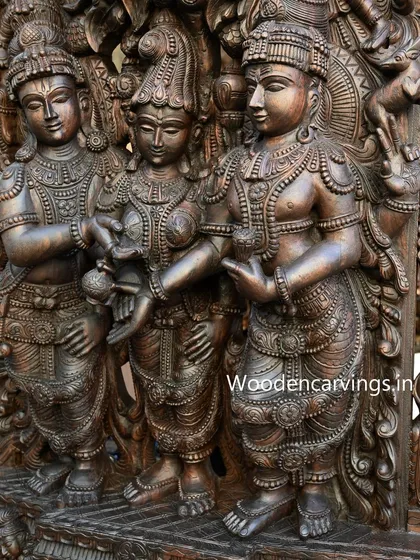 A close-up of the central figures in the Meenakshi Thirukalyanam sculpture. The gentle interaction and detailed expressions of Lord Vishnu, Goddess Meenakshi, and Lord Shiva are captured with profound skill and devotion.