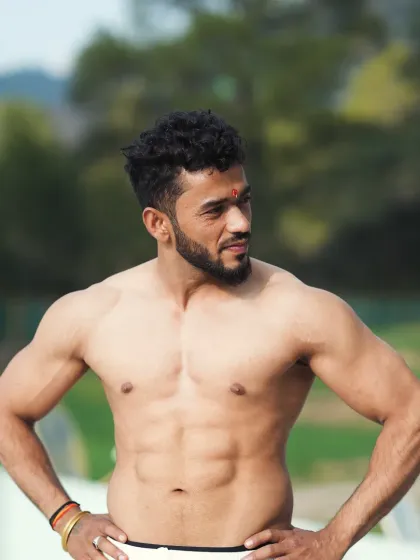 A classic physique pose, highlighting the chest, shoulders, and abs. This is the aesthetic we build with smart training.