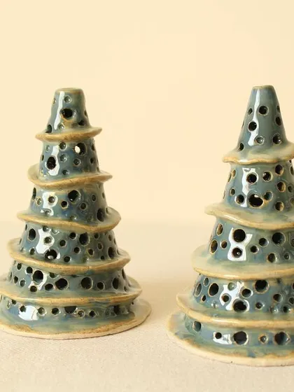My Winter Wonderland Christmas tree luminaries feature a unique tiered shape and are perforated by hand. The glaze gives them a beautiful, rustic blue-green finish.