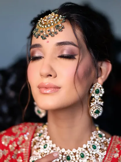 A close-up on the eye makeup from the red lehenga shoot. The soft brown and gold tones create a warm, sultry look that is perfect for a bride.