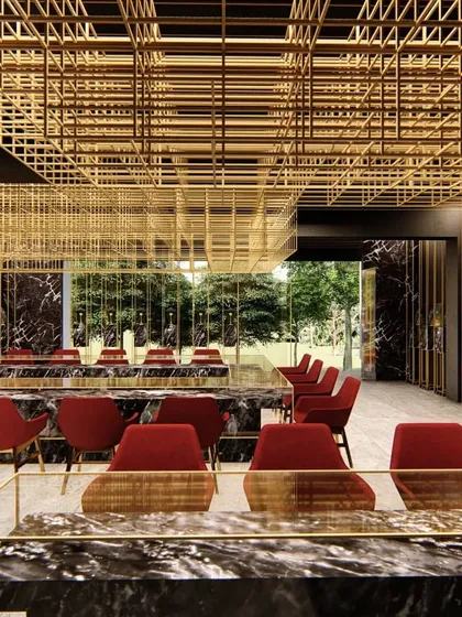 For this Lucknow jewellery showroom, we designed a suspended brass mesh that defines the space and functions as a dramatic lighting installation, contrasting with dark marble and bold red accents.