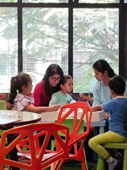 An instructor helps children with their craft projects during our Dusshera camp. Our team is always on hand to guide and inspire the kids.