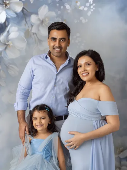 A classic family portrait with everyone looking towards the camera, capturing a beautiful moment in time for this growing family.
