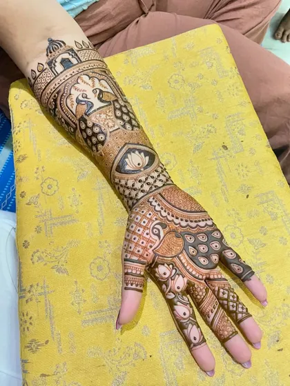 A beautiful bridal arm design with a peacock, a lotus, and architectural elements. The combination of fine lines and bold fills makes the design stand out.