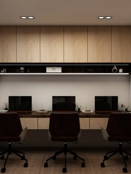 A sleek, modern workstation for three, featuring light wood cabinetry and integrated task lighting. The design is minimalist and highly functional, with glass partitions separating it from other office areas.