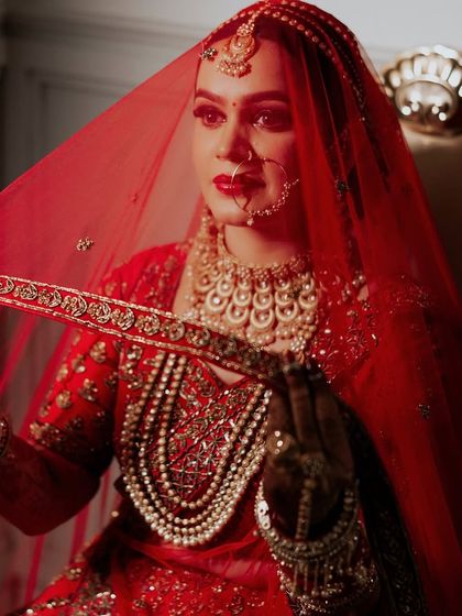 Confidence is the best accessory. This bride's look is all about power and grace, with a red veil framing her perfectly applied makeup.