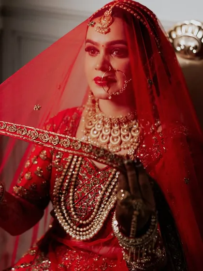 Confidence is the best accessory. This bride's look is all about power and grace, with a red veil framing her perfectly applied makeup.