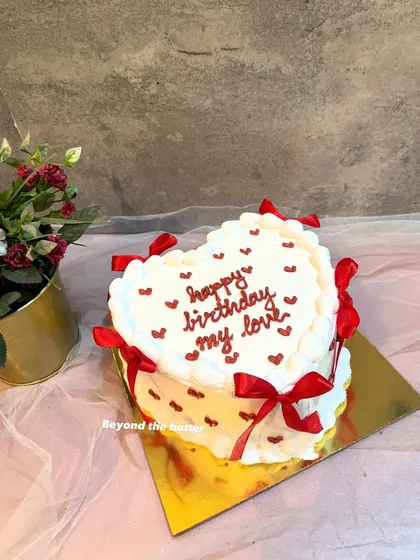I love making these vintage-style heart cakes. This one features delicate buttercream piping, tiny red hearts, and elegant red ribbons, creating a timeless look for a special birthday. It’s a beautiful way to express your love with a classic design.