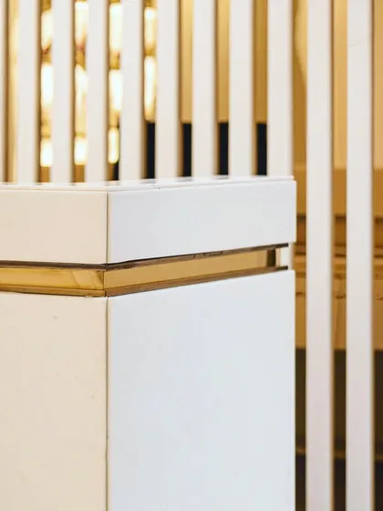 A corner detail showing the precise joinery of white marble and brass inlay. This level of detail and material combination is a signature of our luxury design approach.