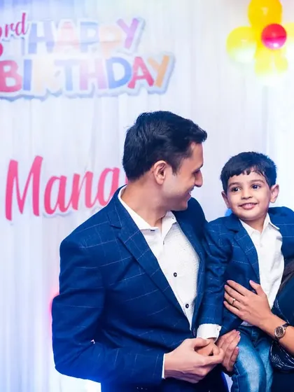 A sweet family photo of the parents with their three-year-old son at his birthday celebration.