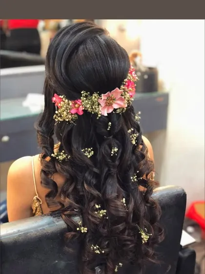 Half-up, half-down hairstyle with beautiful curls and a floral hairpiece. This is a versatile look that works for many different occasions.