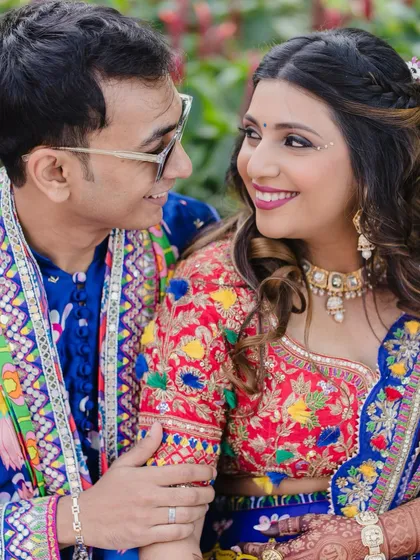 A sweet couple shot from the carnival. The bride's vibrant makeup looks stunning next to her partner's colorful outfit.