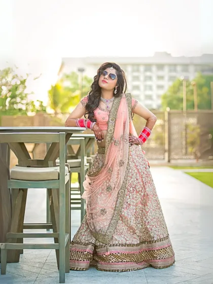 A modern bride with a stylish attitude. This portrait captures her posing with sunglasses, blending traditional attire with a cool, contemporary vibe.