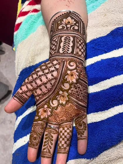 A close look at the fine details that make a design special. This image highlights the clean lines of the jaal (net) pattern on the back of the hand, the delicate shading in the lotus motifs, and the precise leaf patterns on the fingers.