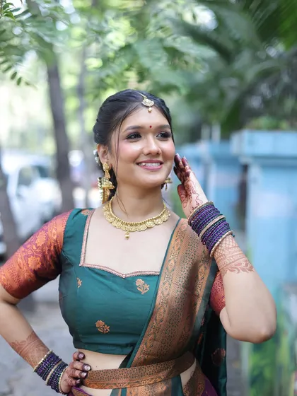 A close-up of the South Indian look, showing the defined eyes, gold jewelry, and traditional hairstyle.