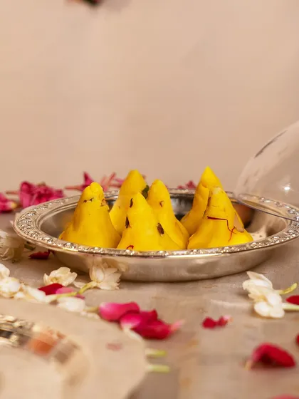 The sweetest offering for Ganesh Chaturthi. Freshly made modaks are presented in a simple yet elegant silver-plated dish, ready to be offered with love and devotion.