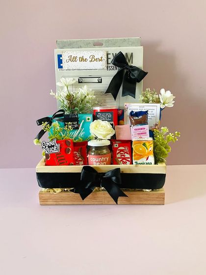An "All the Best" hamper for a student facing board exams. I filled it with essentials like a clipboard, stationery, and brain-food snacks for good luck.
